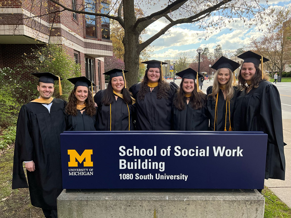 Spring 2023 JCLP graduates standing in front of the School of Social Work
