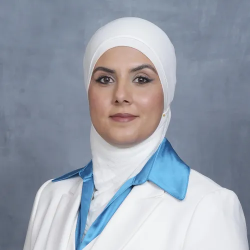 Professional headshot of Amal Issa wearing a white hijab and white blazer.