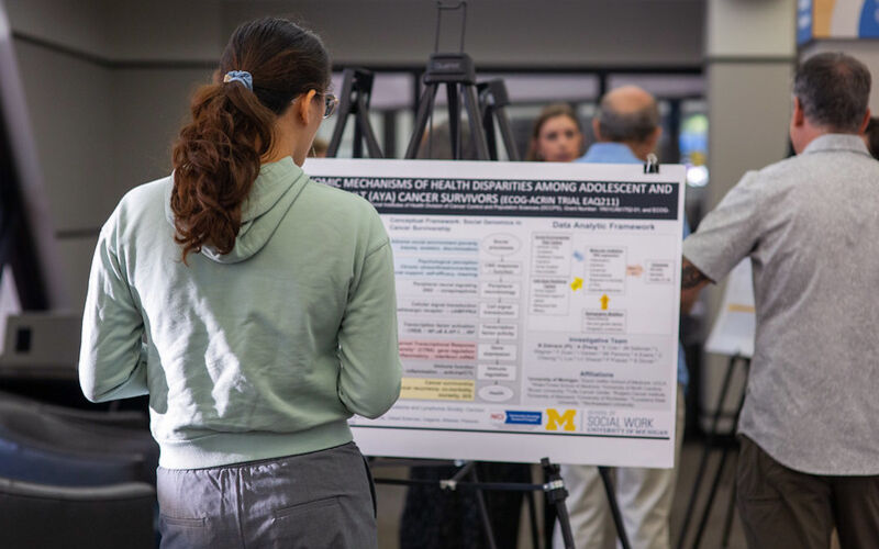 Student looking at a research poster.