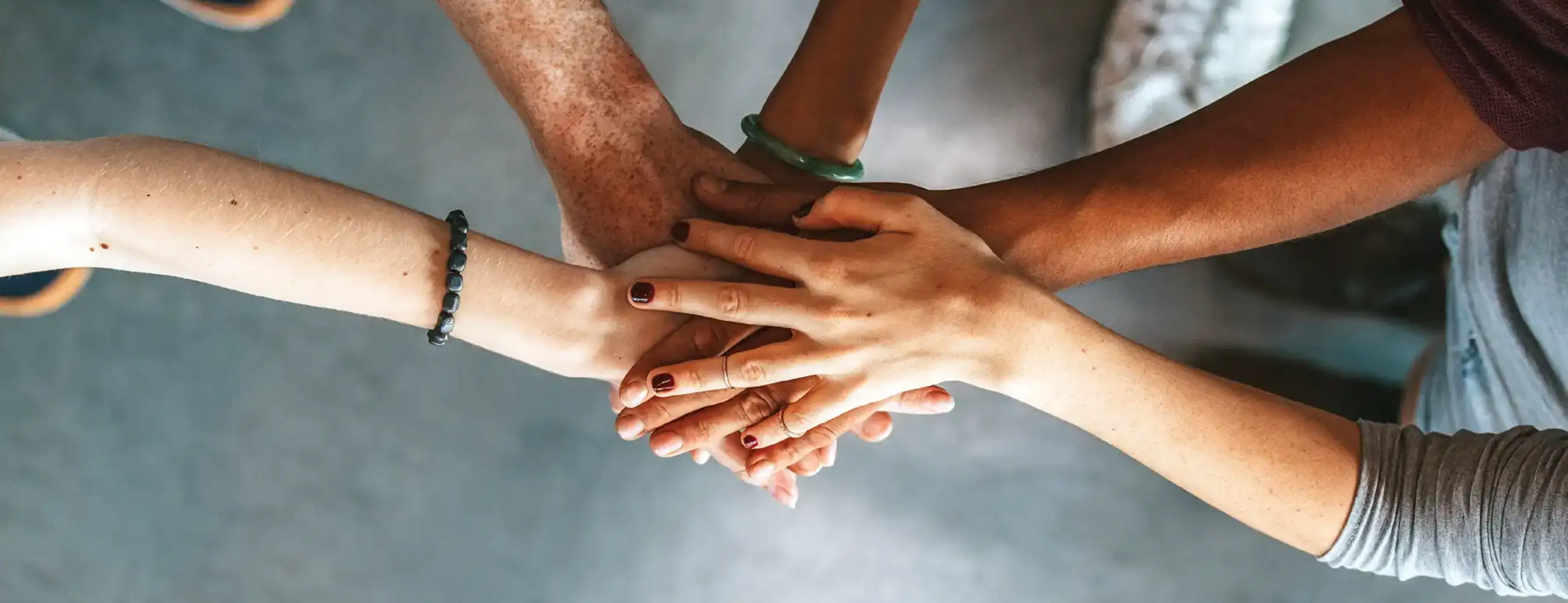 People placing their hands on top of each other.