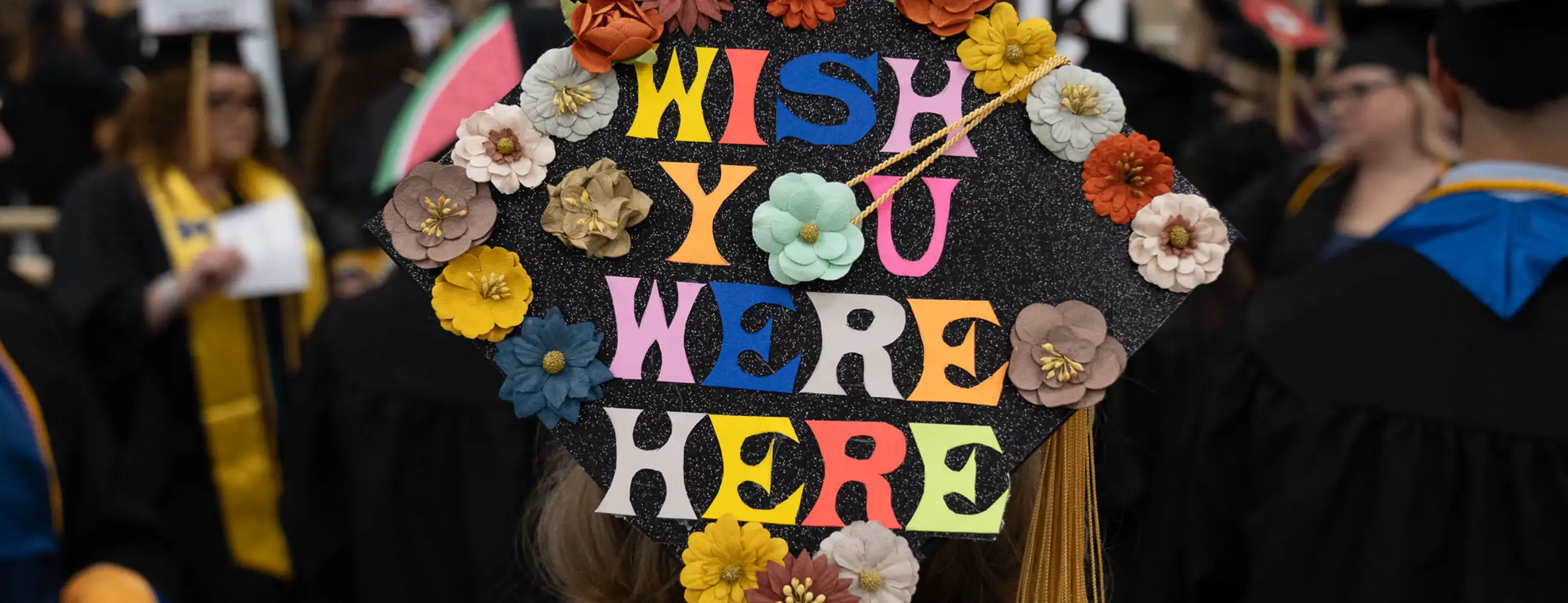 Student mortarboard cap that says "Wish You Were Here"