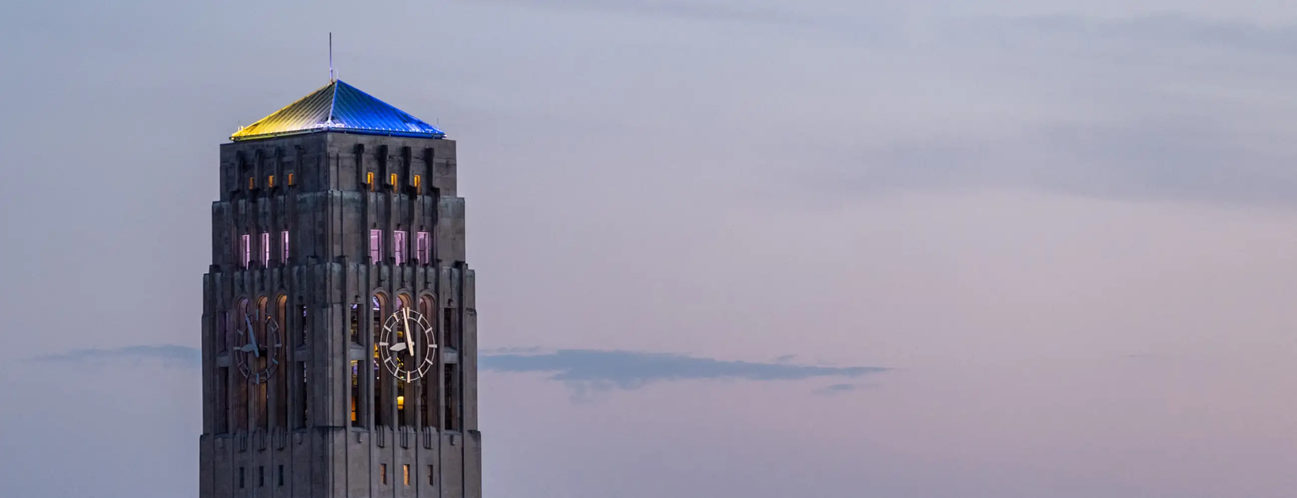 Photo of Burton Tower illuminated with U-M colors.