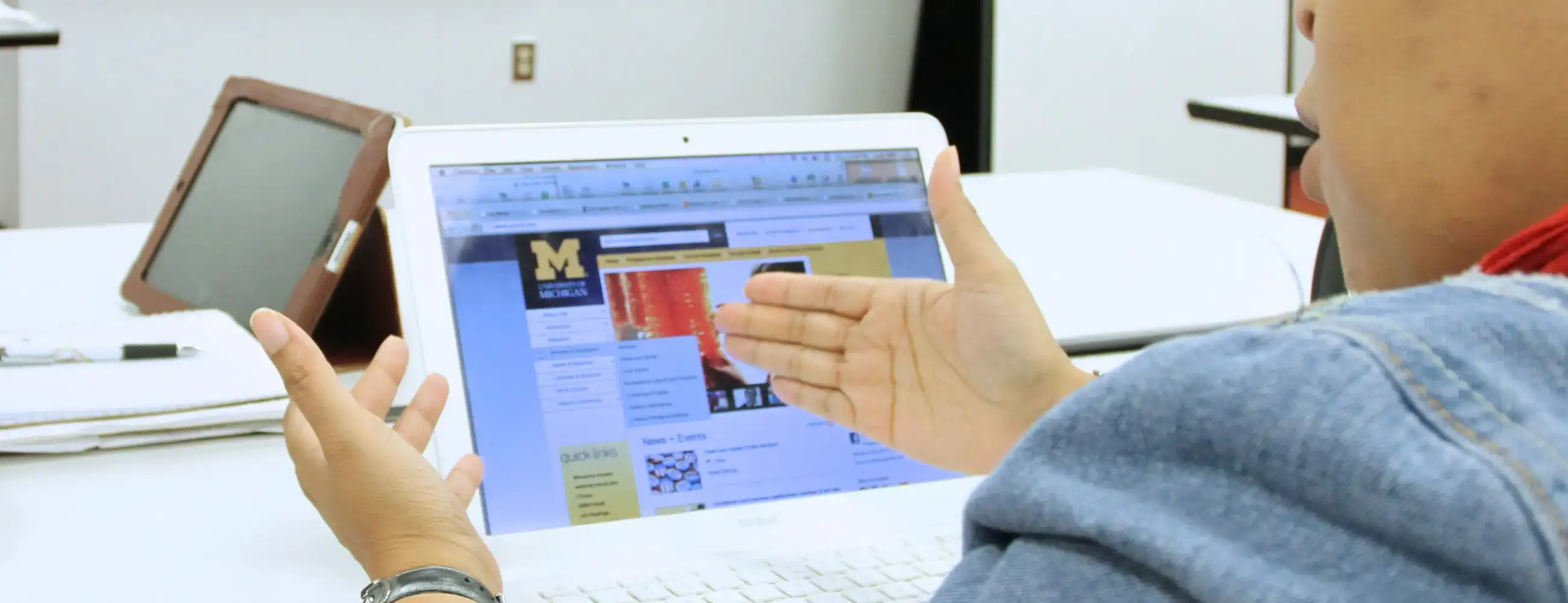 A U-M student in front of a laptop explaining something.