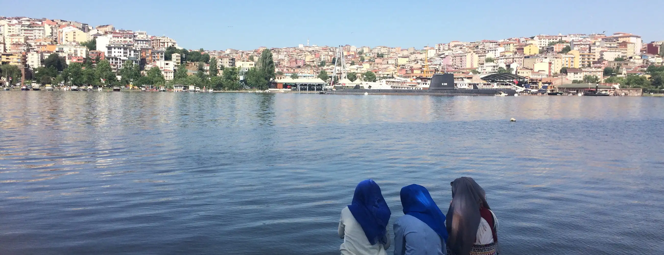 3 people sitting by a river in Istanbul 