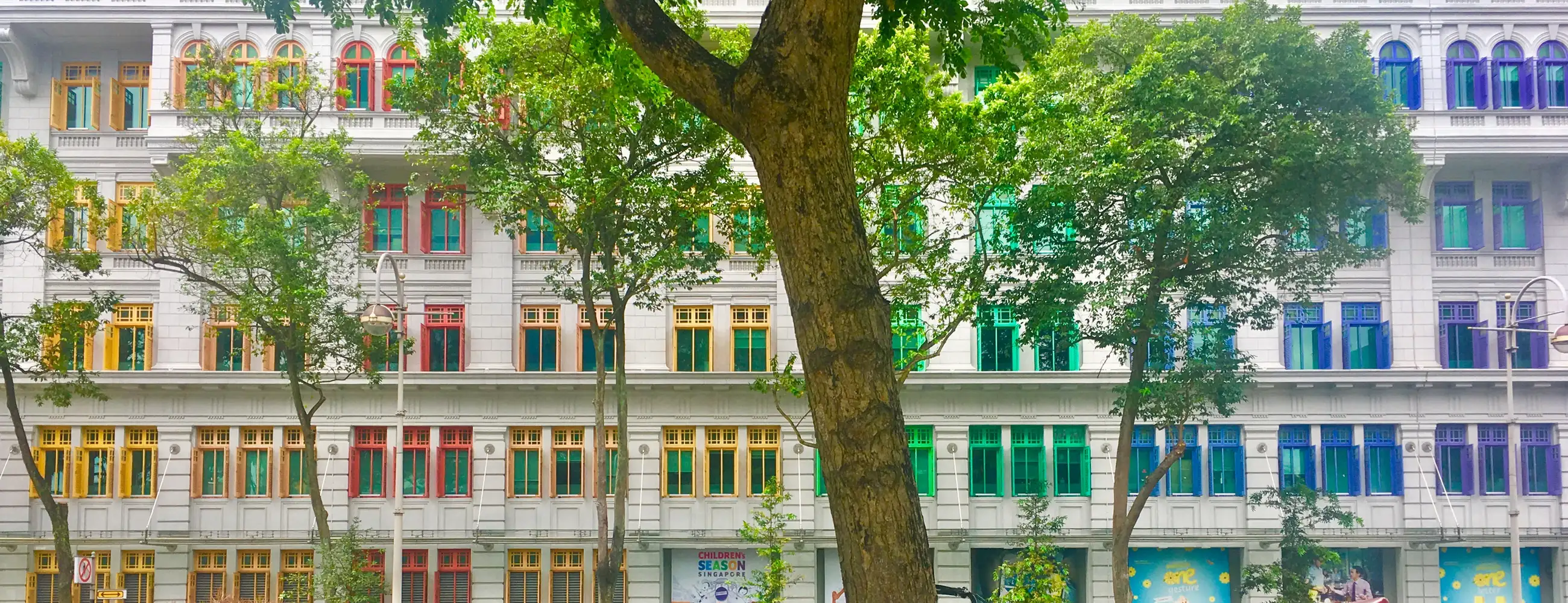 A picture of a building with rainbow trim on the windows