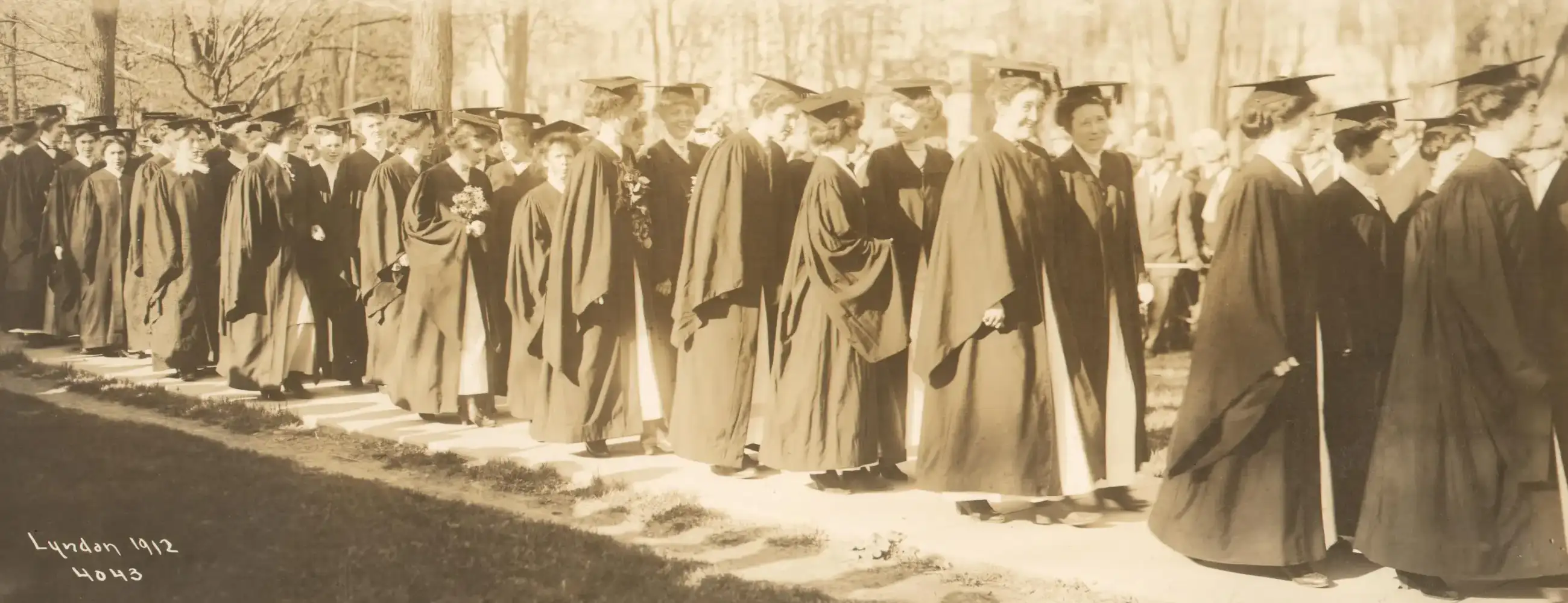 A 1912 photo of women graduating in their caps and gowns.