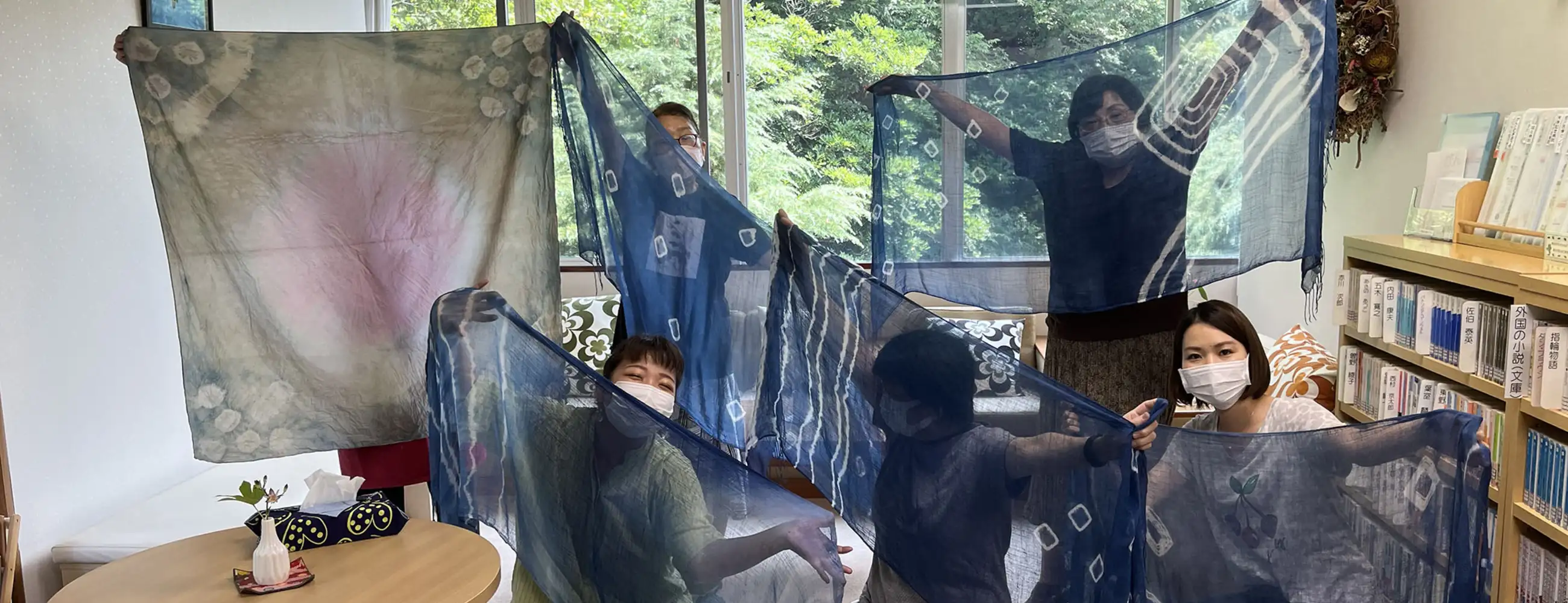 People holding up dyed cloths
