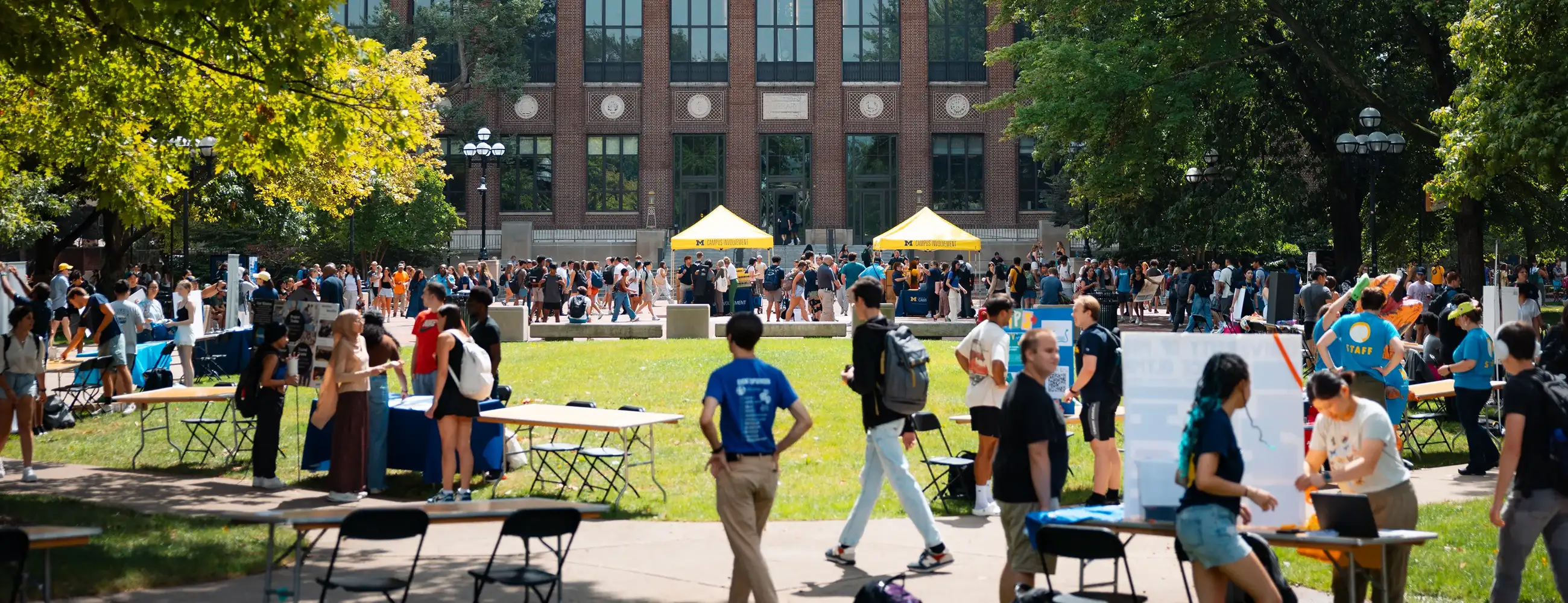 Students gather among tables and tents on the Diag in front of the Hatcher Graduate Library during Festifall, U-M's fall student organization fair.